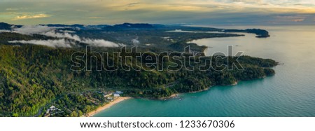 Aerial panoramic view of a tropical beach, jungle and town at sunset (Khao Lak, Thailand)