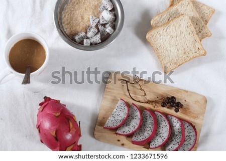 Flat lay healthy vegan breakfast of oatmeal topped with dragon fruit and whole wheat bread slices on the side