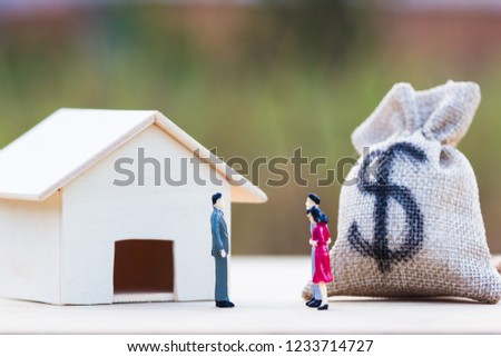 Home bargain, real estate, loan, house lender reverse mortgage concept : Three Miniature bargain front small residence on wooden table and blurred green nature as background. Trading house.