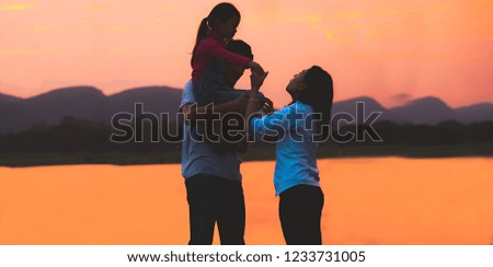 Silhouette Happy Asian Family Enjoying Family Time at Sunset.Available space