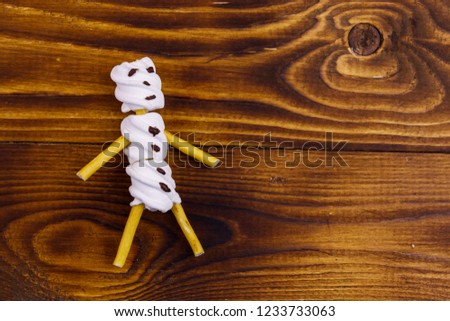 Marshmallow snowman on wooden background