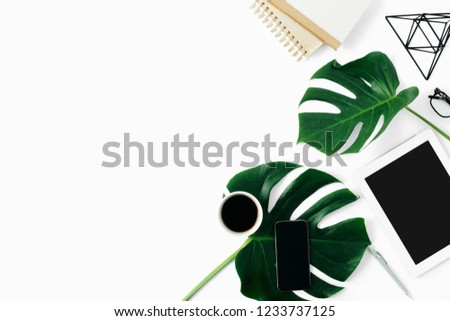 Office table desk feminine fashion workspace with tablet, accessories and monstera leaves flat lay, top view