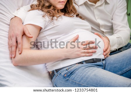 Close up man hugging pregnant wife in medical clinic