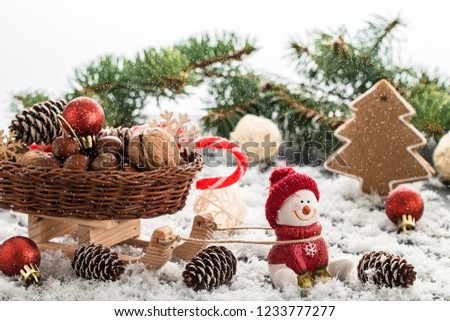 Snowman in a red cap on wooden table. Christmas or New Year composition with gifts and gingerbread cookies. Winter holiday composition. 