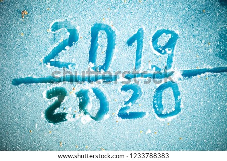 The inscription 2019 and 2020 on the glass by hoarfrost.
