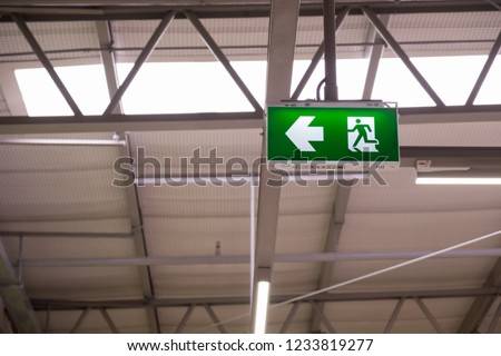 Fire exit light sign. Green emergency exit sign showing the way to escape.
