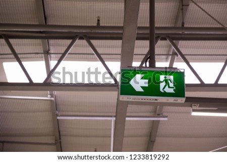 Fire exit light sign. Green emergency exit sign showing the way to escape.
