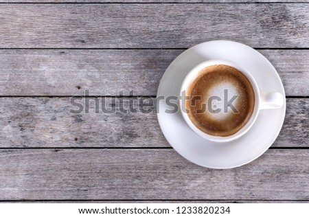 Cappuccino White coffee cup on old wood floor Vintage, top view.
