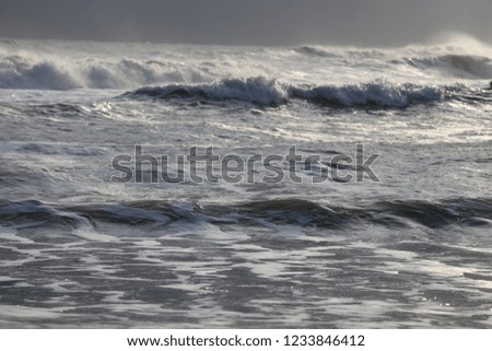 Close up front view of the mediterranean sea during a sunny windy day. Pattern of white waves and splashes with sunlights. Symbol of movement. Abstract picture. 