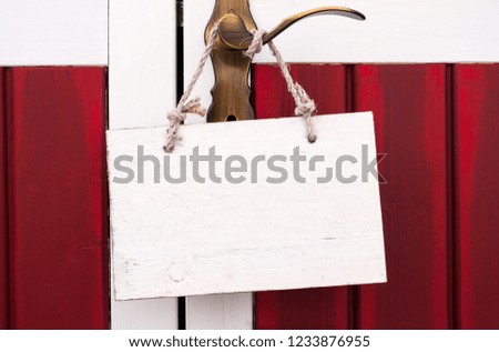 Wooden sign board on a golden door handle