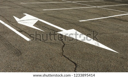 white arrow signs on the asphalt road