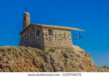 small orthodox church hiking point for pilgrims in mountain rocks nature landscape environment in clear weather time on empty blue sky background