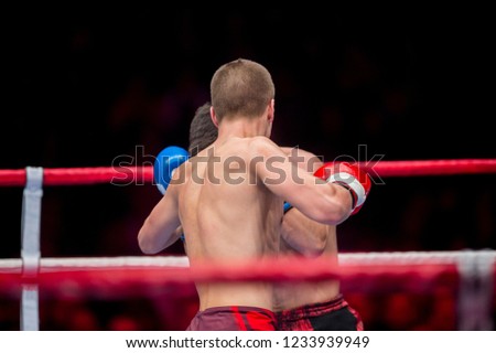 Men kickboxing. Two confident men kickboxing on the ring