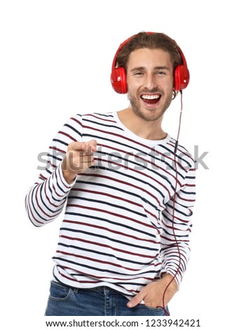 Young man listening to music on white background