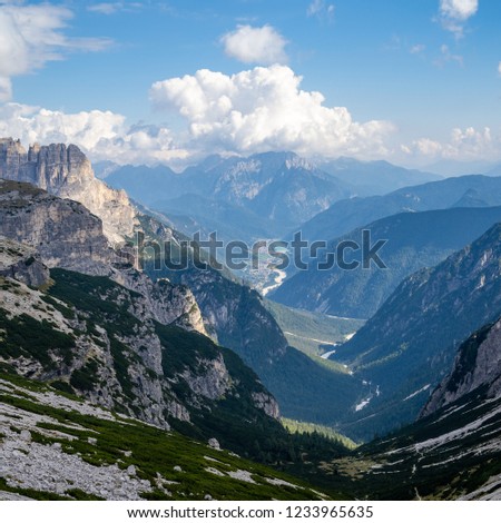 A square picture of the auronzo di cadore valley on a clear day with few puffy clouds