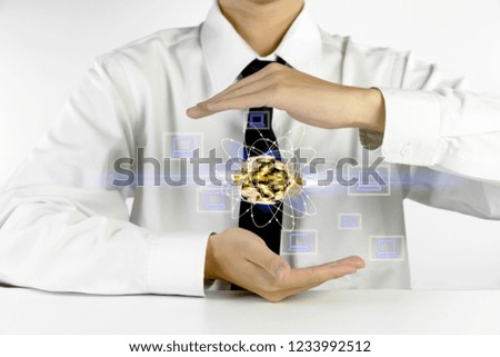 businessman hands protecting piles of golden coins with laptop icons