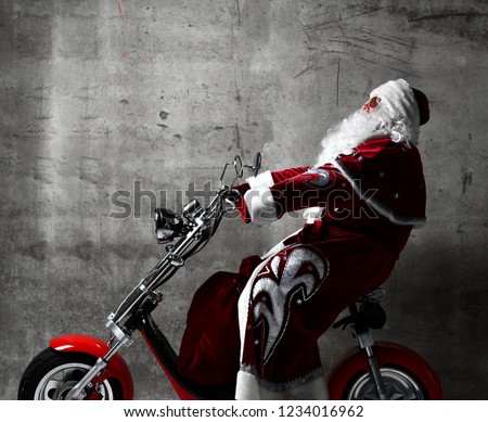 Santa Claus ride electric motorcycle bicycle scooter with bag full of presents and text copy space. New year and Merry Christmas and happy holidays concept