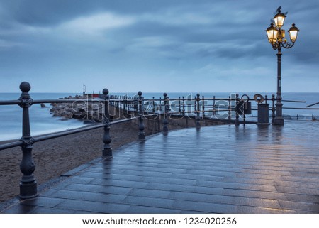 street lighter in dark morning twilight on the pier on amalfi coast in Italy