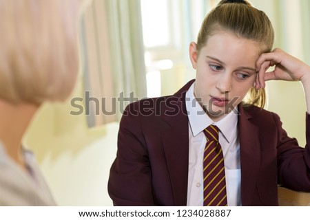 Depressed Teenage Girl Wearing School Uniform Meeting With Counselor Royalty-Free Stock Photo #1234028887