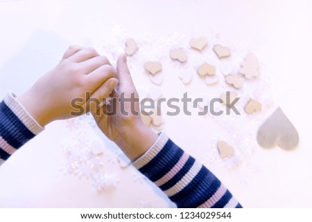 Small paper snowflakes in child's hands. Gift decoration process.