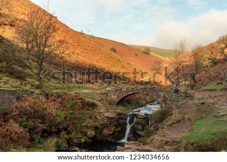 A waterfall and packhorse stone bridge at Three Shires Head in the Peak District National Park.