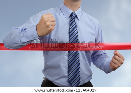 Racing to first place at the red ribbon finish line concept for winning and success Royalty-Free Stock Photo #123404029