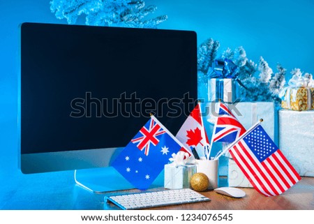 Congratulations on Christmas on the computer monitor. Happy New Year. Computer with New Year's gifts. Congratulations in England, USA, Canada, Merry Christmas and Happy New Year.