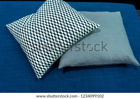 Modern fabric pillow checkered pattern on blue fabric sofa interior