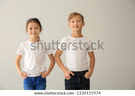 Cute children in t-shirts on light background