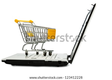cart standing on the keyboard of a laptop, symbol photo for online shopping and consumer behavior