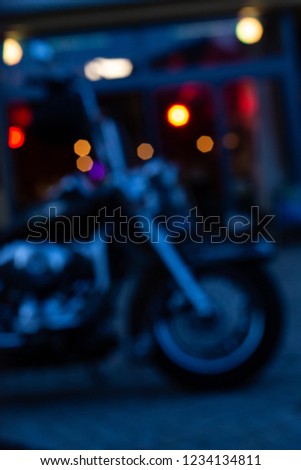 blurred bistro and pub neon lights at evening in city mall of south germany metropole with motorbike parts