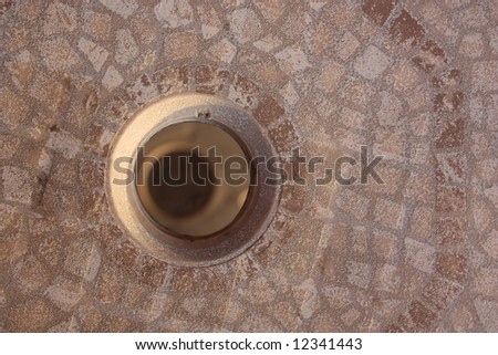 Patterned concrete plate with hole; close up