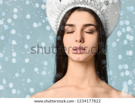 Beauty portrait of young attractive woman in russian traditional cap hat kokoshnik, over snowy Christmas background