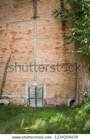 Zinc gate with old bricks wall and grass field, stock photo