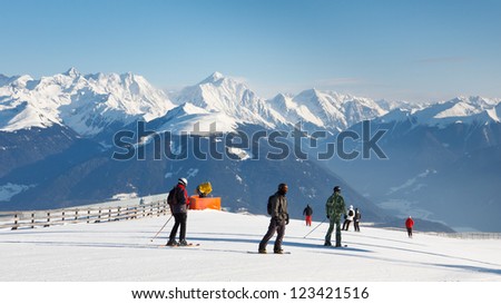 Skiers enjoy the fantastic alpine panorama on a sunny winter day.