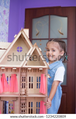 Little girl in room with toy house