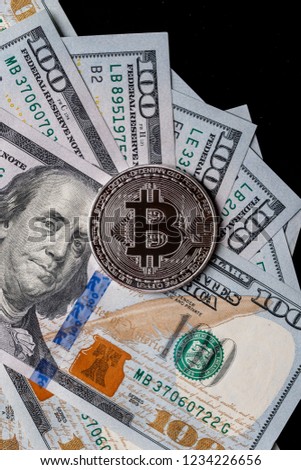 Background with crypto bitcoin and dollars. A symbolic coins of bitcoins on banknotes of one hundred dollars. Exchange bitcoin cash for a dollar.