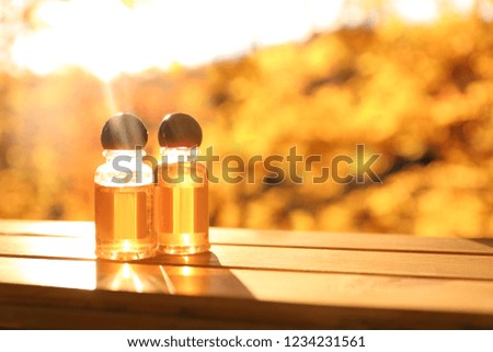 Bottles with essential oil on blurred background. Space for text