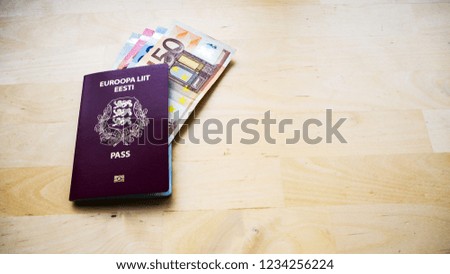 Passport on the wooden background. Passports of Estonia and European Union (EU)  Top view. Copy space for design. Euro banknotes. Toned picture