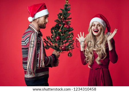 a man with a Christmas tree next to a joyful woman                   