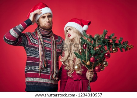 man and woman in Christmas hats Christmas tree                       