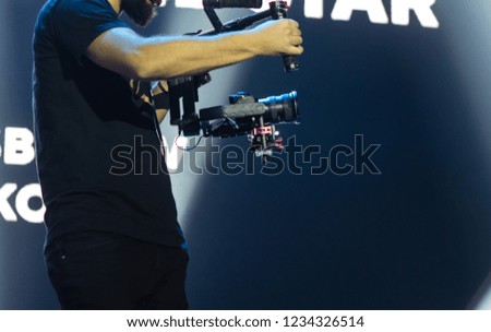 Professional videographer holding camera on 3-axis gimbal. Videographer using steadicam. Pro equipment helps to make high quality video without shaking