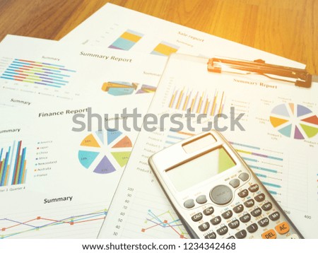 Business report chart and Financial graph analysis with calculator on table.