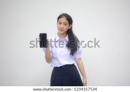 Portrait of thai high school student uniform teen beautiful girl show her phone