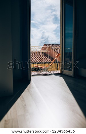Open window with city roofs view in Italy. Light and shadow in room. Travel and relax concept
