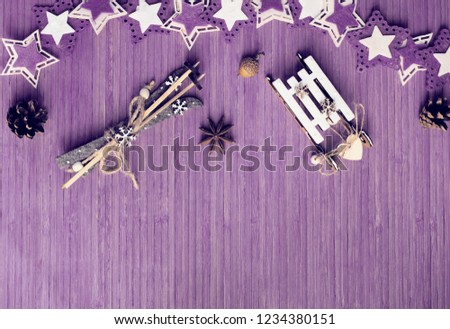 Winter composition with star anise, acorn, pine cone, colorful felt stars, decorative sledge and ski on the wooden background. Top view