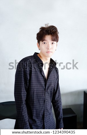 Handsome asian CASUAL man stand and smile posing on gray background.
Portrait of young KOREAN against gray background Royalty-Free Stock Photo #1234390435