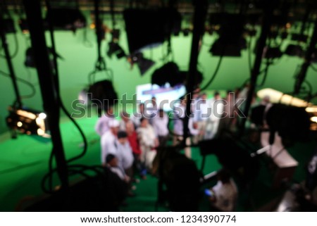 Blurred image of production team people are talking with their project for setting equipment on the green scene and using the virtual studio. Atmosphere in the studio To broadcast live on television. 