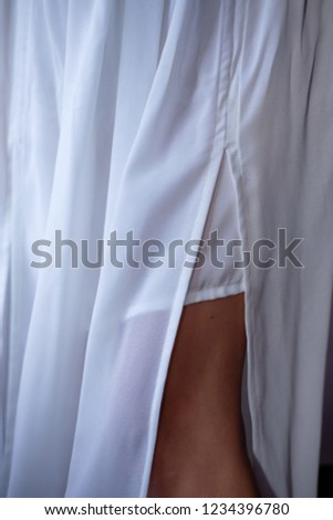 bride legs in white wedding dress in cold light wedding preparing concept, defocused