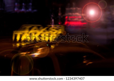 A long exposure picture taken in night time on the street of Izmir, showing a TAXI that is traveling - photography